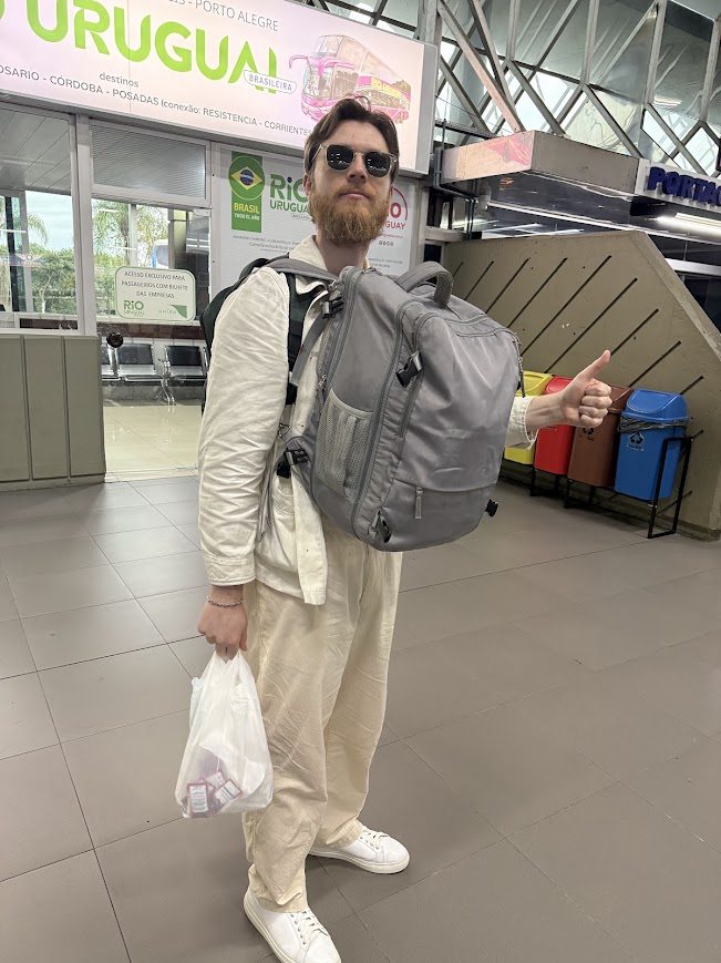 The Bad Digital Nomad carrying a large backpack at a bus terminal
