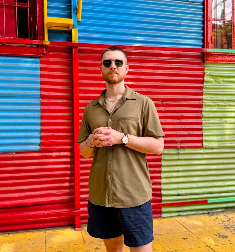 The Bad Digital Nomad in front of a wall painted red, blue, and green